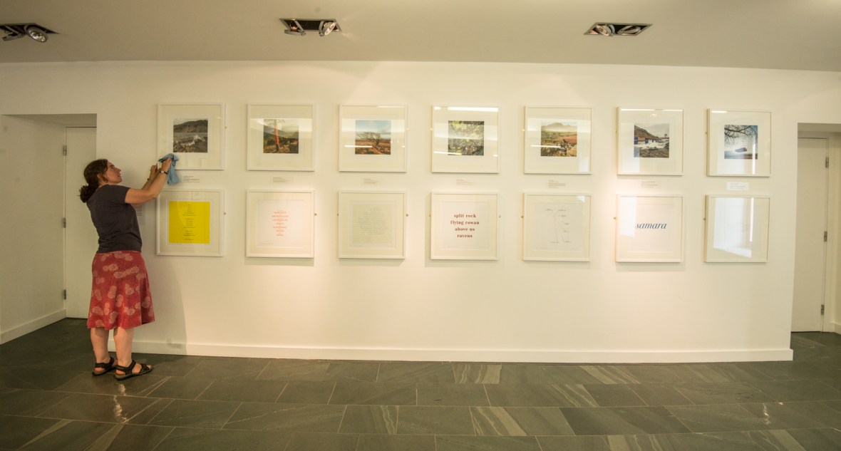 Harriet cleaning up the frames on the Fragmented Rainbow wall of the exhibition