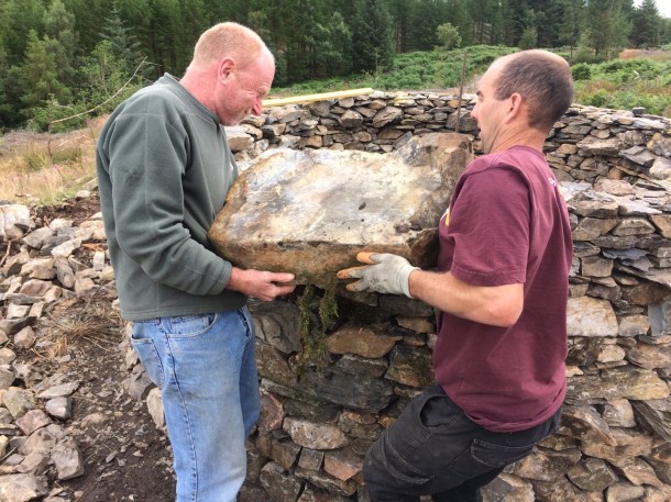 Rob Fraser and Andrew Mason lifting a corner stone at treefold:centre Grizedale